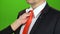 Woman`s hand adjusts the tie around her servant`s neck. Green screen. Close up