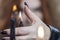 A woman`s hand with a black manicure will hold a burning candle. Mysticism and the occult. Close-up. Selective focus