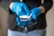 Woman& x27;s hand in blue gloves cleaning smartphone mobile phone with wet wipes