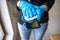 Woman& x27;s hand in blue gloves cleaning smartphone mobile phone with wet wipes