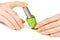 Woman\'s hand with a bottle of green nail polish