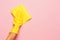 The woman`s hand cleaning on a pink background. Cleaning or housekeeping concept