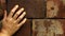 Woman`s hand clenched against brick wall