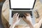 woman\'s hand on computer notebook with eyeglasses on wooden desk