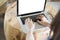 woman\'s hand on computer notebook with eyeglasses on wooden desk