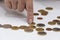 A woman`s hand counts metal coins from a wallet on a table on a white background. Concept: small pension, poverty, lack of money f