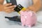 woman\'s hand with a credit card and a piggy bank, next to a calculator on the table. crisis and inflation. Cost