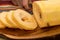 A woman`s hand cuts a large zucchini on slices on a wooden board