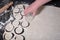 A woman`s hand cuts out the circles with a glass of rolled dough layer