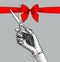 Woman`s hand cutting with scissors a red ribbon with bow.
