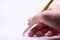 A woman`s hand is erasing something with the rubber sticking with the pencil on the white background