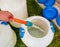 A woman\'s hand fills a plastic barrel with water from a hose. The concept of the drinking water crisis in the world