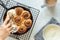 Woman`s Hand Frosting Cinnamon Rolls in Skillet