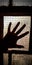 A woman& x27;s hand on glass window looking horror