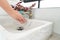 The woman`s hand is going to open the faucet to wash hands. To maintain cleanliness after entering the bathroom, the concept of