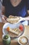 Woman`s hand grabbing a peanut butter, banana and strawberry toast on a table with fresh juice and coffee