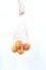 Woman`s hand is on hold string bag with oranges and grapefruits. Concept zero waste, eco-friendly