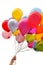 Woman`s hand holding bunch of multicolored balloons