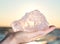 Woman`s hand holding gem grade rough Rose Quartz chunk from Madagascar