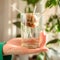 Woman`s hand holding growing avocado seed in water. Plant parent concept