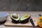 A woman`s hand holding a knife to divide half of the avocado