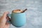 Woman`s hand holding mug of coffee, cocoa or hot chocolate with whipped cream and cinnamon. Cozy drink for cold autumn