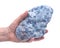 Woman`s hand holding raw blue calcite cluster