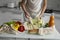 Woman`s hand, holding a reusable grocery bag with vegetables on a kitchen at home and takes zucchini out. Zero waste and