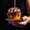 Woman\\\'s hand holding a saucer with chocolate cupcake, close up. Hand holding cupcake. Creamy chocolate