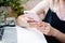 Woman`s hand holding smartphone in cozy summer office with laptop and green plants