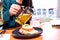 Woman`s hand holding teapot and pouring tea into a white cup near plate of smoked salmon toast