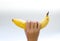The woman\'s hand holds a banana, is isolated on a white backgrou