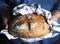 Woman`s hand holds a fresh baked rustic vine bread.