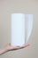 A woman`s hand holds a roll of paper kitchen towels. Vertical image