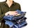 A woman`s hand holds a stack of clean folded ironed things made of blue cotton denim. Cleaning the closet. Love for