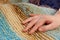 The woman`s hand lies on knitted multicolored handmade plaid, close-up, creative background