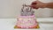 Woman\\\'s hand lighting candles for happy birthday on cake