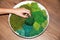 A woman`s hand makes a round panel of green stabilized moss for ecological interior decoration of an office or apartment