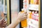 Woman`s hand open convenience store refrigerator shelves and pic