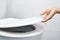 Woman`s hand opening the toilet lid