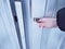 A woman`s hand opens the metal door of an iron fence.