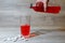 A woman\'s hand pours a red sports drink or lemonade into a glass Cup from a plastic bottle. Energy drink in glass and plastic bot