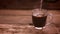 A woman`s hand pours a spoonful of coffee into a cup and fills it with water