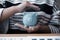 Woman`s hand protects a piggy bank save money with a pile of coins, steps into a successful growing business, and saves it for