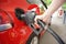 Woman`s hand pumps gas into car