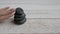 A woman`s hand pushed a stack of stones on the table