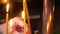 A woman's hand puts a burning candle near an orthodox cross in a church. Church Prayer Concept