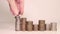 A woman`s hand puts coins in a column. Investment concept. Metallic currency