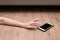 Woman`s hand reaches for mobile phone. Emergency concept