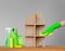 A woman`s hand in a rubber glove washes the symbolic house with a green cloth, next to the house - a colourful set of tools for cl